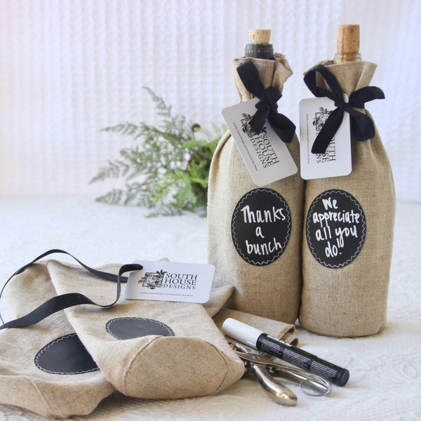 a chalk marker and supplies are shown on a table where wine bottle gift bags are being assembles